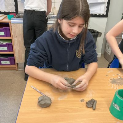 Children making clay lizards